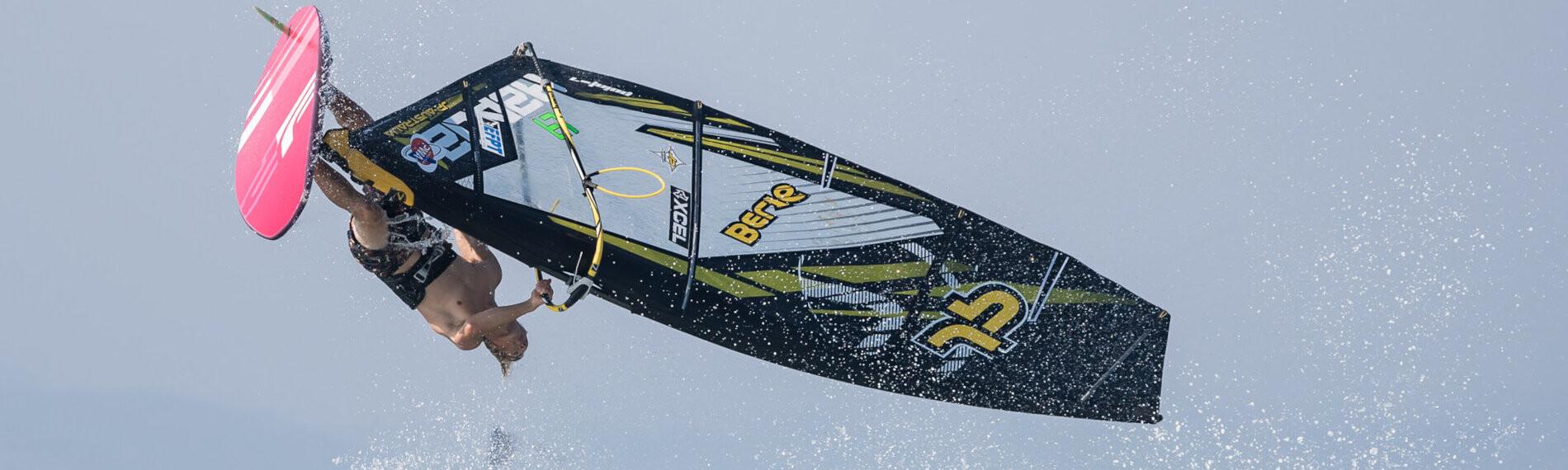 Windsurfer führt einen Sprung über Wellen aus, blauer Himmel im Hintergrund, in Theologos auf Rhodos