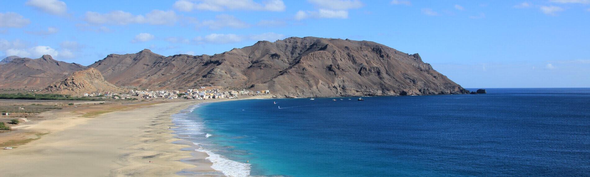 Sao Vicente Surfrevier Küstenlandschaft mit Strand, blauem Meer und Gebirge im Hintergrund bei klarer Sicht.